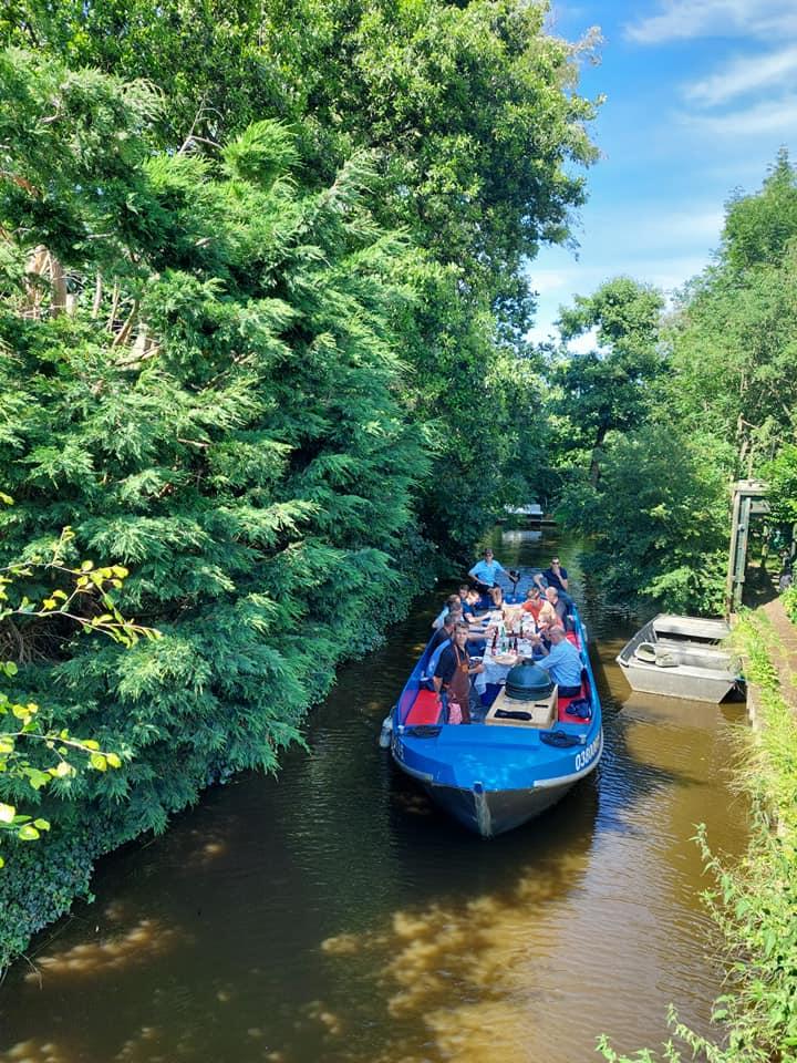 Grote blauwe boot met meerdere personen aan boord